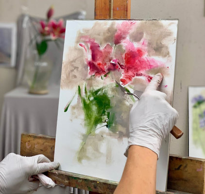 Cynthia Rowland is teaching a pupil during a painting class